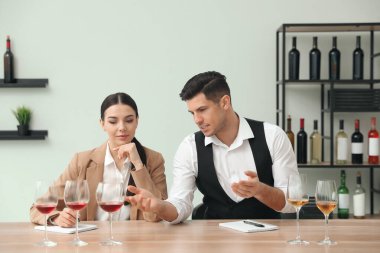 Sommelier 'ler kapalı bir masada farklı türde şarap tadıyorlar.
