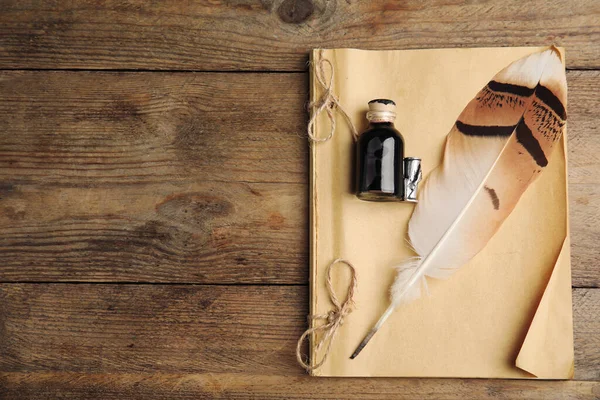 羽毛笔 一瓶墨水和笔记本在木制桌子上 顶部视图 案文的篇幅 — 图库照片