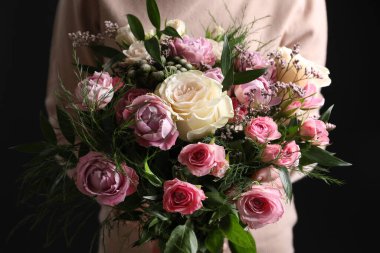 Siyah arka planda gül buketi olan kadın, yakın plan.