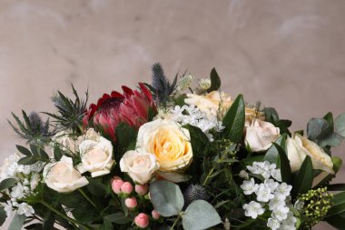 Bej arka planda güller olan güzel bir buket, yakın plan.