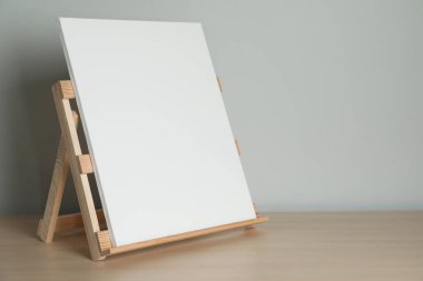 Masada boş tuval olan ahşap sehpa. Metin için boşluk