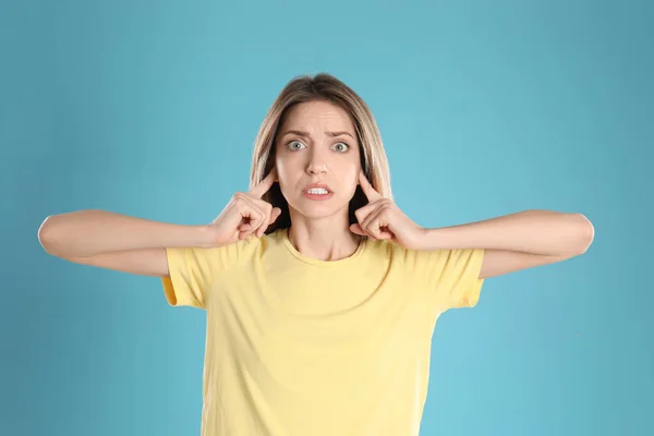 Emotionale Junge Frau Bedeckt Ihre Ohren Mit Fingern Auf Hellblauem — Stockfoto