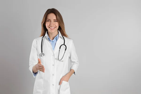 Médica Feliz Oferecendo Aperto Mão Fundo Cinza Claro Espaço Para — Fotografia de Stock