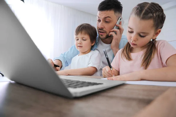 Overwhelmed man combining parenting and work at home