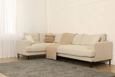 Oturma odasındaki beyaz duvarın yanındaki rahat kanepe.