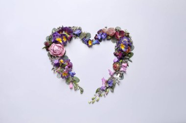 Güzel kalp şeklinde çiçek kompozisyonu açık arkaplanda, düz yatıyordu.