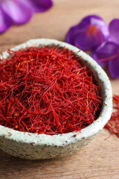 Dried saffron and crocus flowers on wooden table, closeup