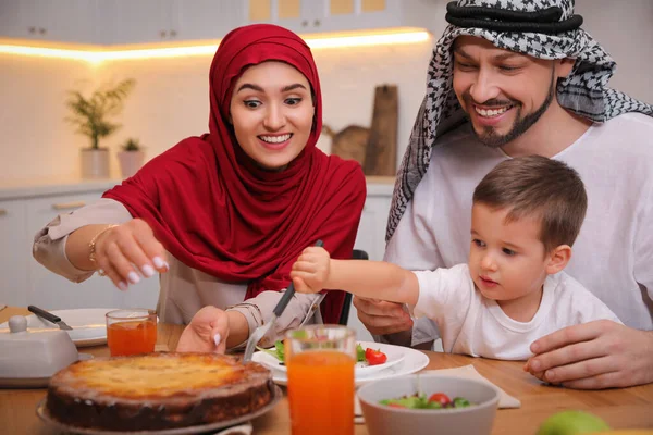 幸せなイスラム教徒の家族一緒に台所でテーブルで食べる — ストック写真