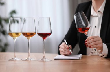 Sommelier içerideki masada farklı türde şarap tadıyor, yakın plan.