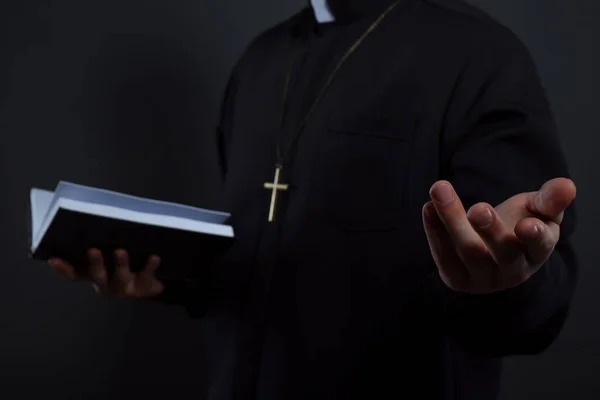 Sacerdote Batina Com Bíblia Sobre Fundo Preto Close — Fotografia de Stock