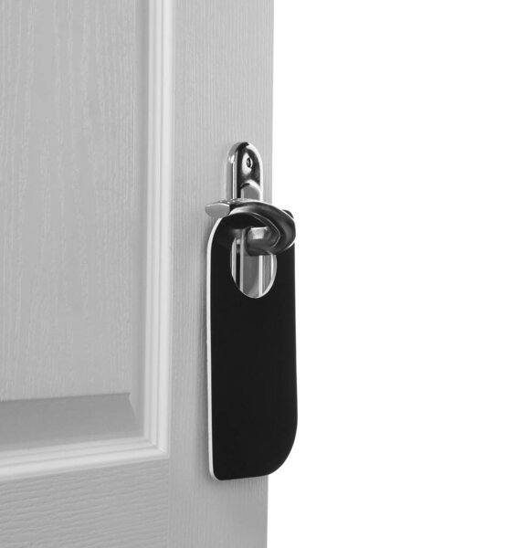 Hotel wooden door with blank hanger on white background, closeup