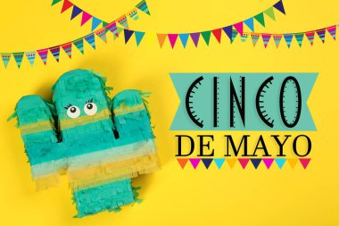 Cinco de Mayo festival posteri. Sarı arka planda parlak komik pinata, üst manzara