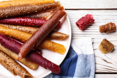 Lezzetli meyve derisi beyaz ahşap masada yuvarlanıyor.