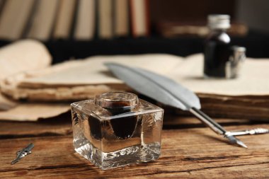 Tüy kalem ve mürekkep hokkası ahşap masaya.