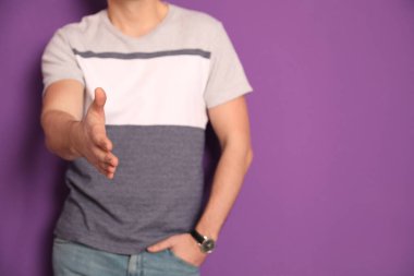 Mor arka planda el sıkışma teklif eden adam, yakın plan. Metin için boşluk