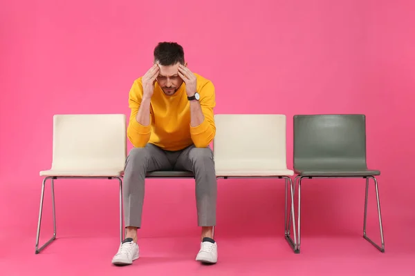 Man waiting for job interview on pink background