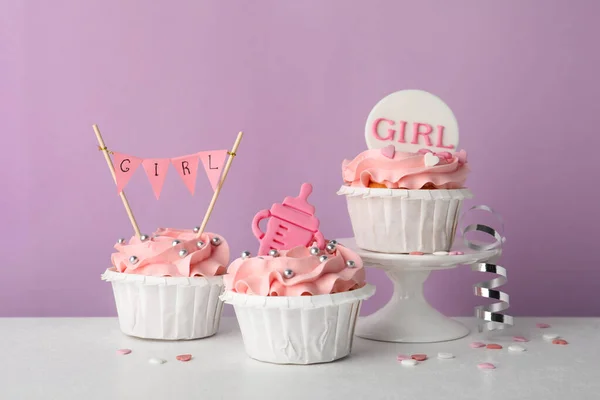 Babeczki Baby Shower Różowym Kremem Toppersami Białym Stole Fioletowym Tle — Zdjęcie stockowe