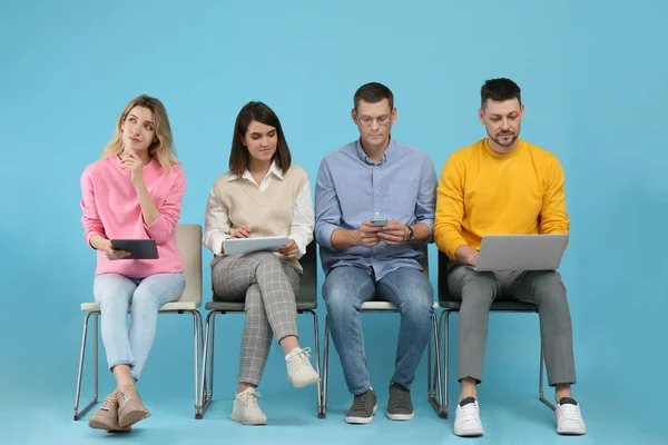 People waiting for job interview on light blue background