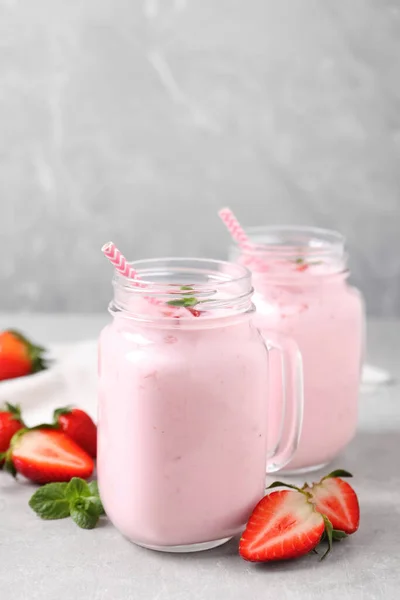 Delicious drink with strawberries on light table