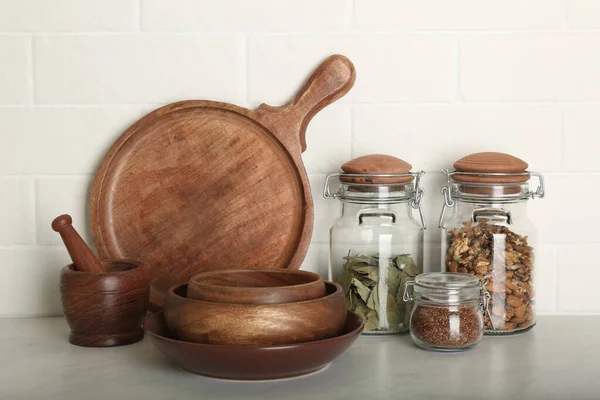 Houten Vaatwerk Diverse Producten Grijze Tafel Bij Witte Bakstenen Muur — Stockfoto