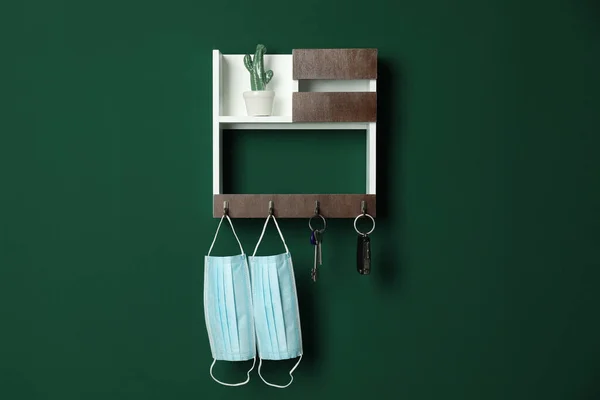 Wooden hanger for keys on green wall