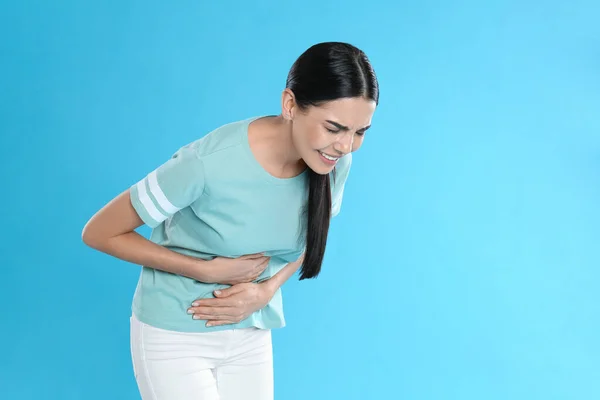 Mujer Que Sufre Dolor Estómago Sobre Fondo Azul Claro Espacio —  Fotos de Stock