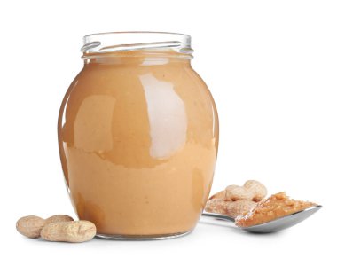 Cam kavanoz ve beyaz arka planda fıstık ezmeli kaşık.