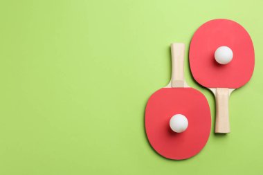 Yeşil arka planda pinpon raketleri ve topları düz yatıyordu. Metin için boşluk