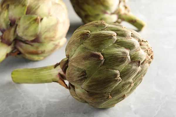 Fresh Raw Artichokes Grey Marble Table Closeup — Stock Photo, Image