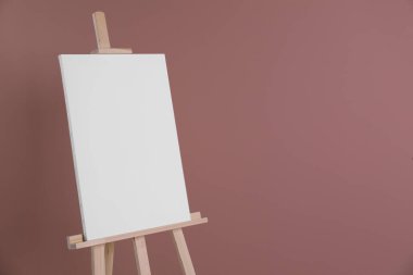 Tozlu gül arka planında boş tuval olan ahşap sehpa. Metin için boşluk