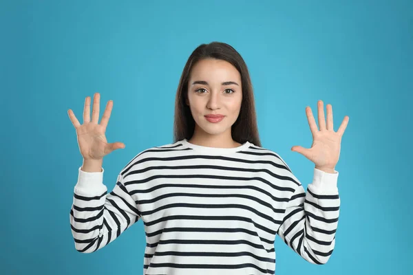 Mujer Mostrando Número Diez Con Sus Manos Sobre Fondo Azul —  Fotos de Stock