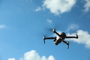Güneşli bir günde gökyüzünde uçan kameralı modern drone