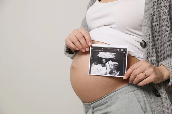 Giovane Donna Incinta Con Ecografia Del Bambino Sfondo Grigio Primo — Foto Stock