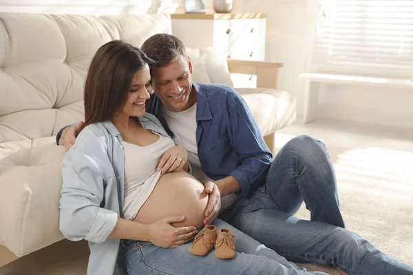 Junge Schwangere Frau Und Ihr Mann Mit Babyschuhen Hause Stockbild