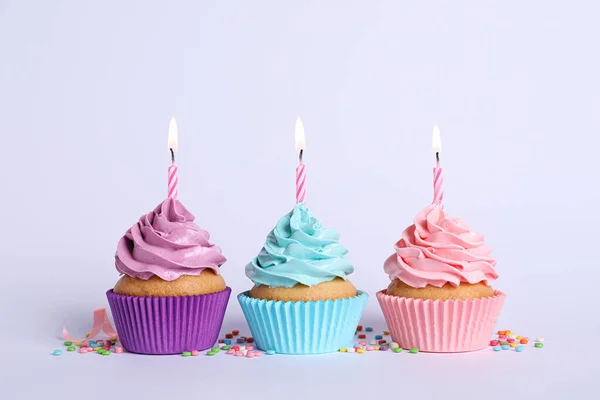 Deliciosos Cupcakes Cumpleaños Con Velas Encendidas Salpicaduras Sobre Fondo Gris —  Fotos de Stock