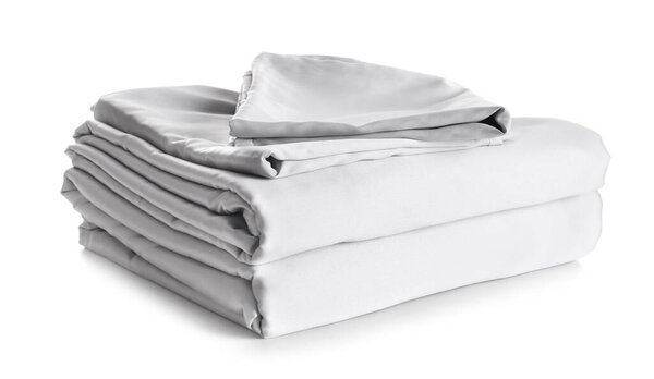 Stack of clean silky bed linen isolated on white