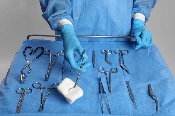 Врач Проводит Медицинские Щипцы Блокнотом Рядом Столом Различных Хирургических Инструментов — стоковое фото