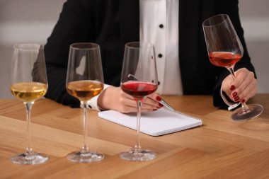 Sommelier içerideki masada farklı türde şarap tadıyor, yakın plan.