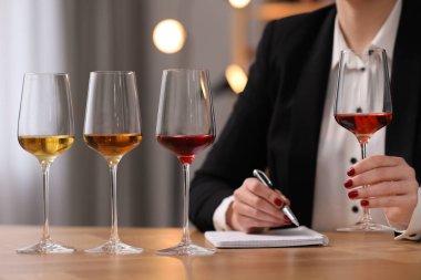Sommelier içerideki masada farklı türde şarap tadıyor, yakın plan.