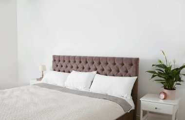 Modern dairede battaniyeli ve yastıklı büyük bir yatak.