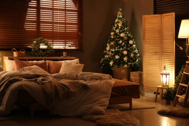 Şenlikli yatak odasındaki dekore edilmiş Noel ağacı.