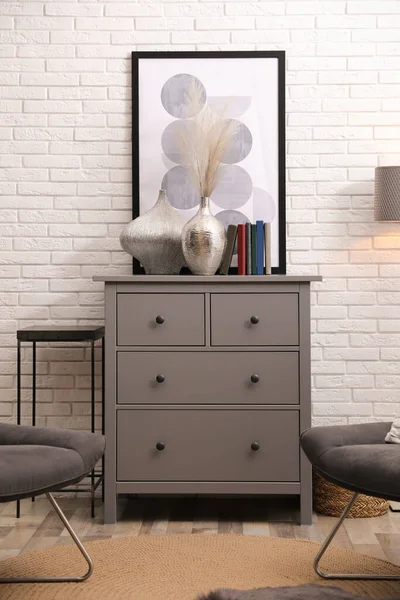 白色砖墙附近的一间风格别致的房间 里面有灰色的抽屉和椅子柜 — 图库照片