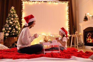 Anne ve kızı evdeki projektör ekranının yanında. Sıcak Noel atmosferi