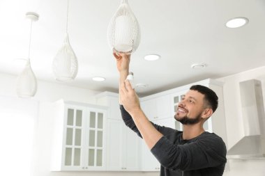 Evdeki ampulü değiştiren adam. Metin için boşluk