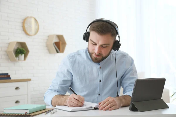 Fiatal Férfi Jegyzetel Online Webinar Során Asztalnál Beltérben — Stock Fotó