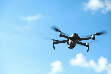 Güneşli bir günde gökyüzünde uçan kameralı modern drone