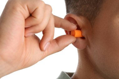 Beyaz arkaplana köpük kulak tıkacı takan adam, yakın plan