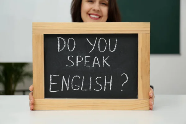 Leraar Met Klein Schoolbord Met Inscriptie Spreek Engels Aan Tafel — Stockfoto