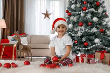 Evde bir kutu Noel topuyla küçük şirin bir kız.