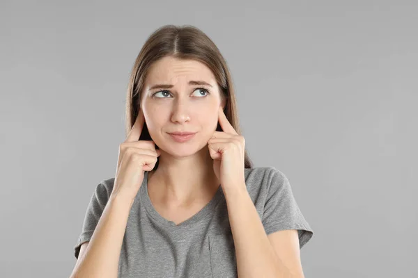 Emotional Young Woman Covering Her Ears Fingers Grey Background — Stock Photo, Image